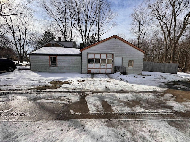 view of front of property with fence and a detached garage