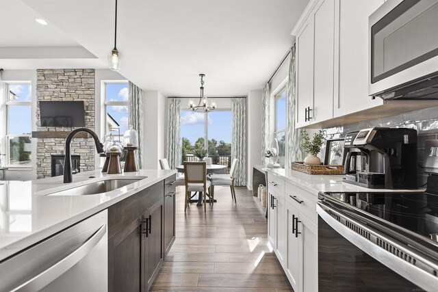 3888 Chatham Pl Unit 99, Brighton, MI 48114 - kitchen with dark wood-style flooring, a sink, white cabinets, light countertops, and appliances with stainless steel finishes