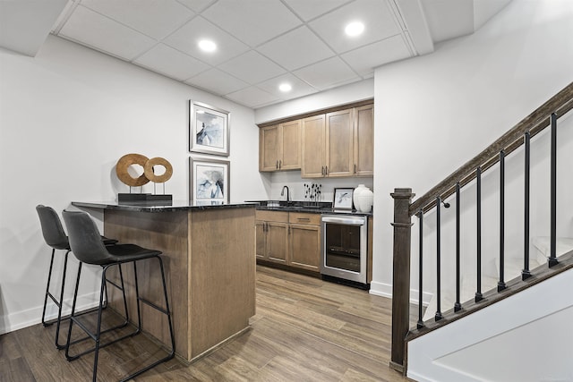 3888 Chatham Pl Unit 99, Brighton, MI 48114 - bar featuring wet bar, beverage cooler, wood finished floors, and stairs