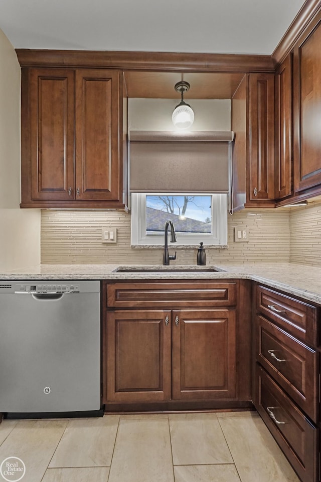 kitchen with light tile patterned floors, a sink, backsplash, light stone countertops, and dishwasher