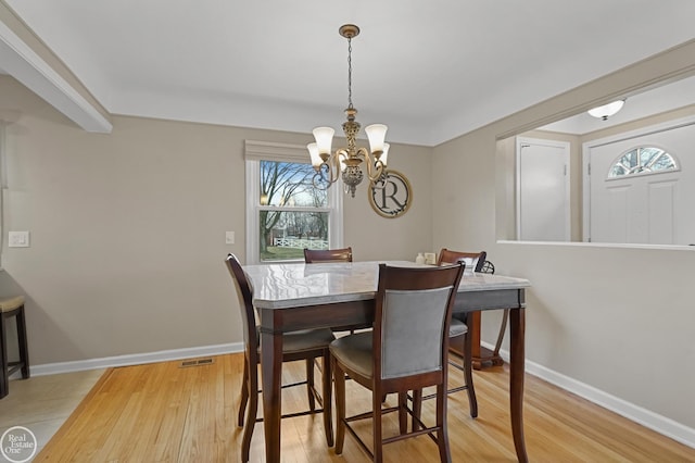 dining area featuring visible vents, an inviting chandelier, light wood-style flooring, and baseboards