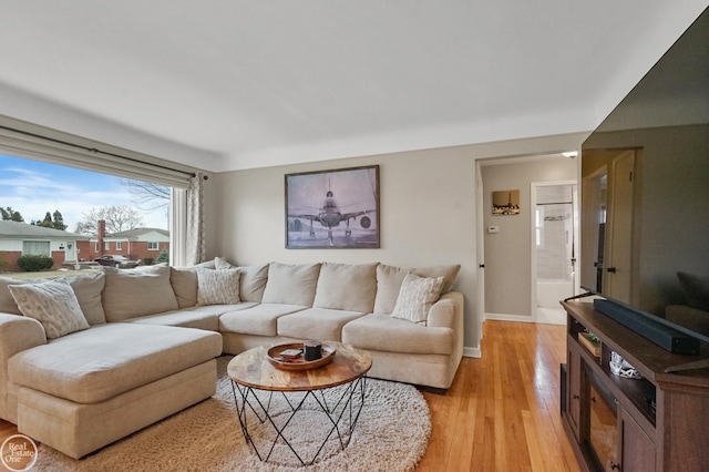 living room with light wood-style flooring and baseboards