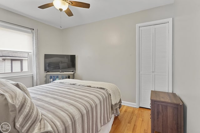 bedroom with light wood finished floors, a closet, baseboards, and a ceiling fan