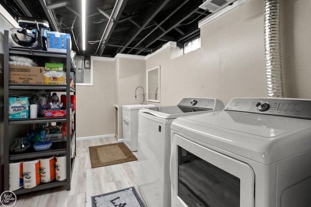 clothes washing area featuring laundry area, separate washer and dryer, and light wood-type flooring