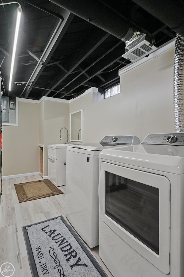 laundry room with laundry area, washer and clothes dryer, and light wood-style floors