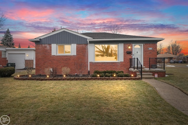 view of front of home with an attached garage, brick siding, and a front yard