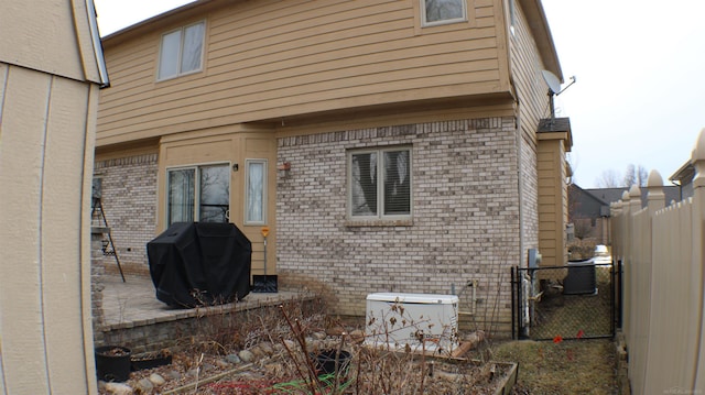 back of house featuring brick siding, a patio, and a fenced backyard