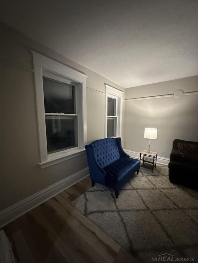 living area featuring baseboards and wood finished floors