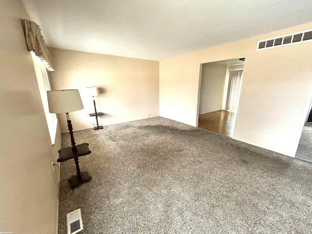 empty room featuring carpet floors and visible vents