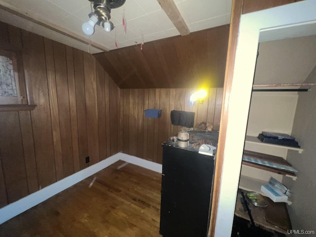 additional living space featuring lofted ceiling, wood walls, baseboards, and wood finished floors