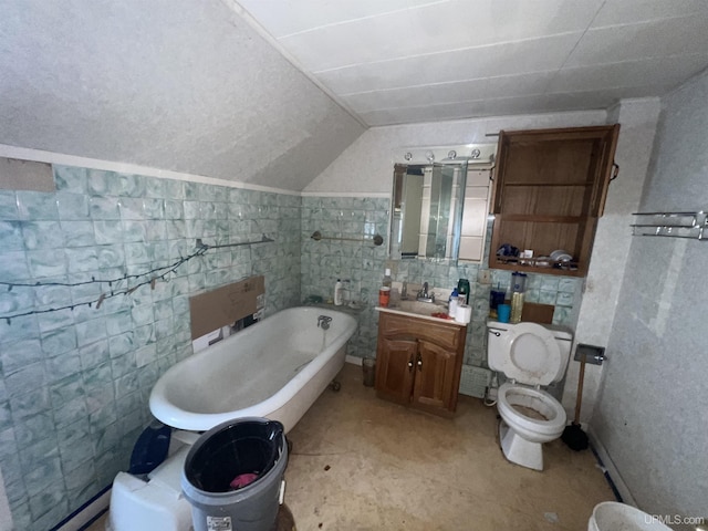 bathroom featuring toilet, a tub, vaulted ceiling, vanity, and tile walls