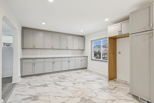 kitchen with recessed lighting, marble finish floor, backsplash, and gray cabinetry