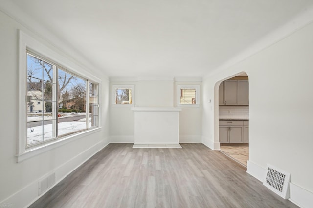 unfurnished room featuring a wealth of natural light, light wood-type flooring, and visible vents