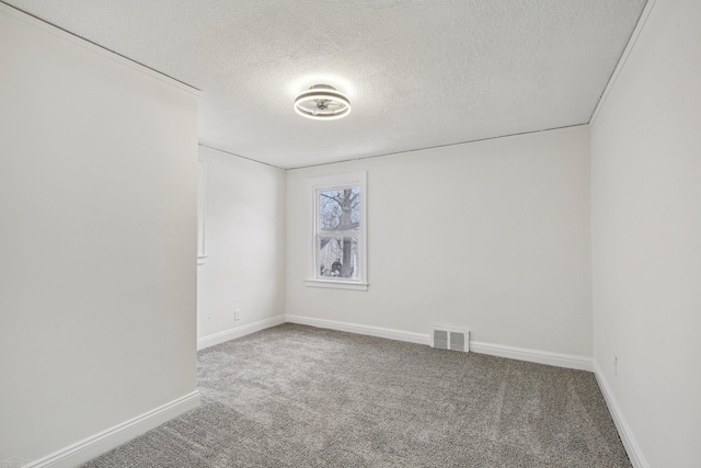 carpeted spare room featuring visible vents, a textured ceiling, and baseboards