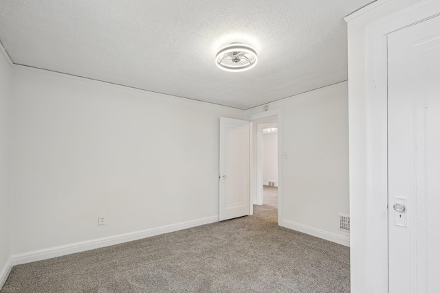 unfurnished bedroom featuring carpet, visible vents, a textured ceiling, and baseboards