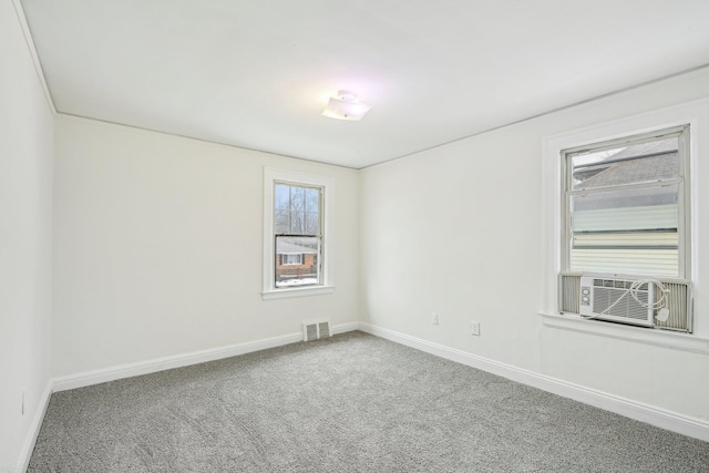 unfurnished room featuring carpet floors, cooling unit, visible vents, and baseboards