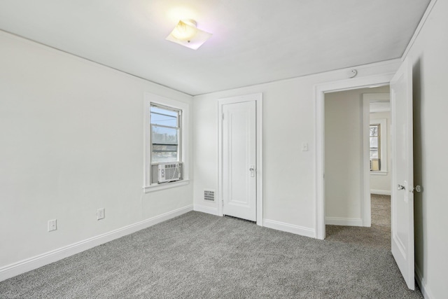 unfurnished bedroom featuring carpet, baseboards, and cooling unit