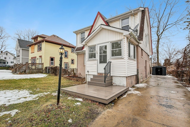 back of house featuring entry steps, a chimney, board and batten siding, and a yard