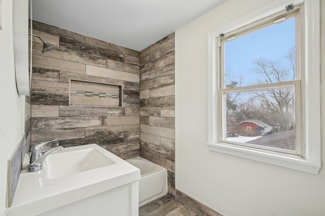 full bathroom with a tub to relax in, plenty of natural light, wood walls, and a sink