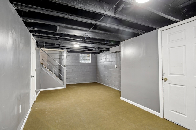 below grade area featuring stairway and baseboards