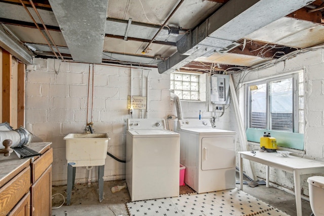 clothes washing area featuring laundry area, electric panel, washer and clothes dryer, and a sink