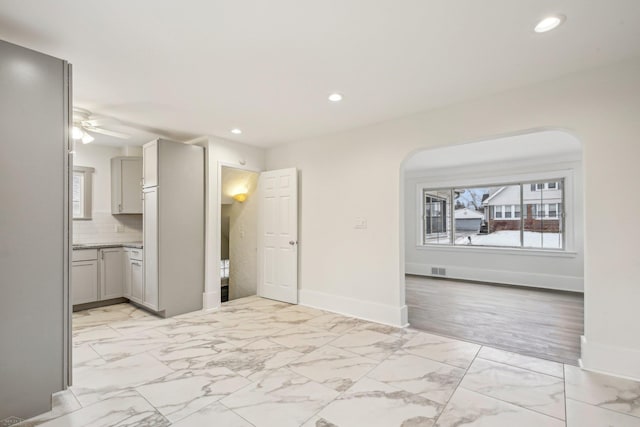 unfurnished room featuring recessed lighting, marble finish floor, ceiling fan, and baseboards