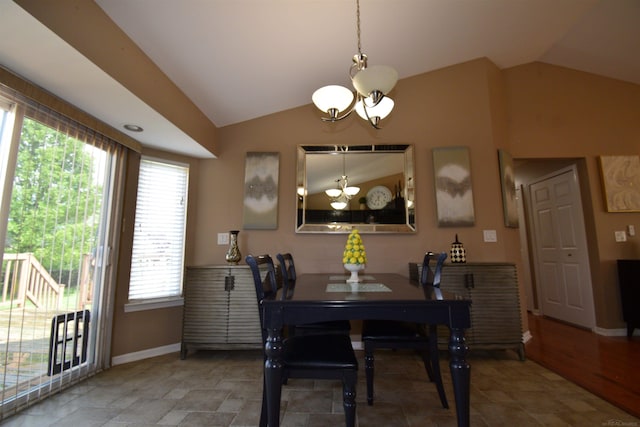 dining space featuring a chandelier, lofted ceiling, and baseboards