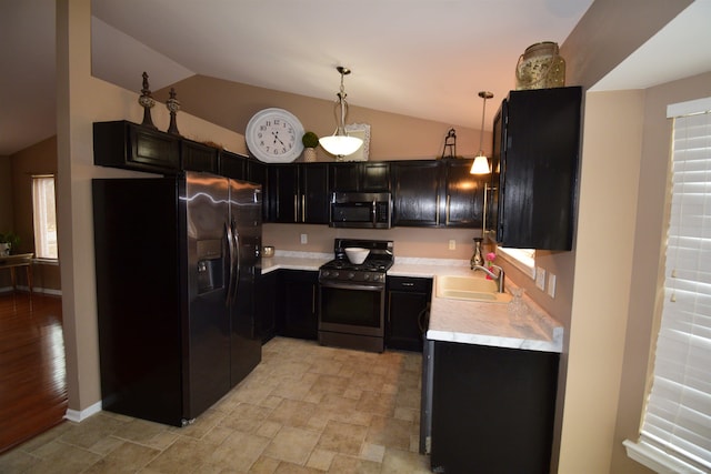 kitchen featuring stainless steel appliances, lofted ceiling, light countertops, and a sink