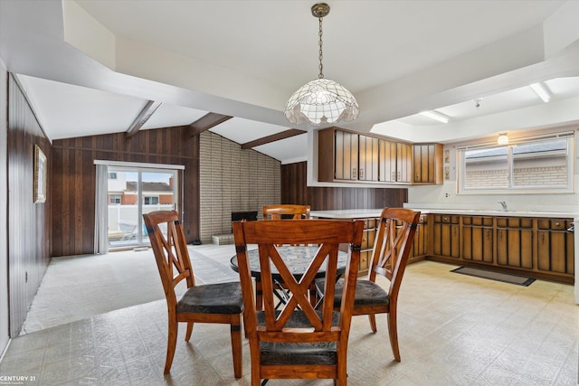 dining room with light floors, wood walls, and a wealth of natural light