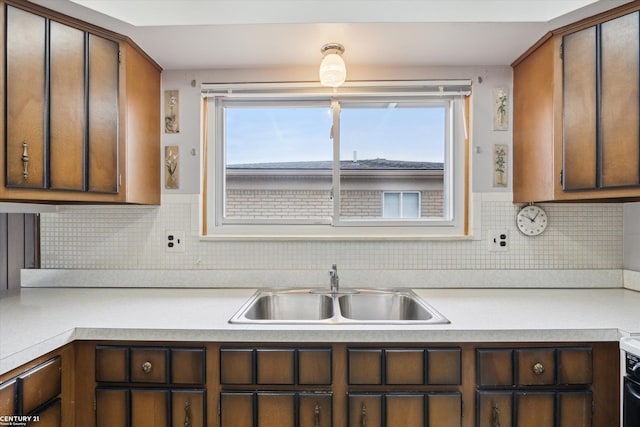 kitchen featuring range, light countertops, a sink, and decorative backsplash