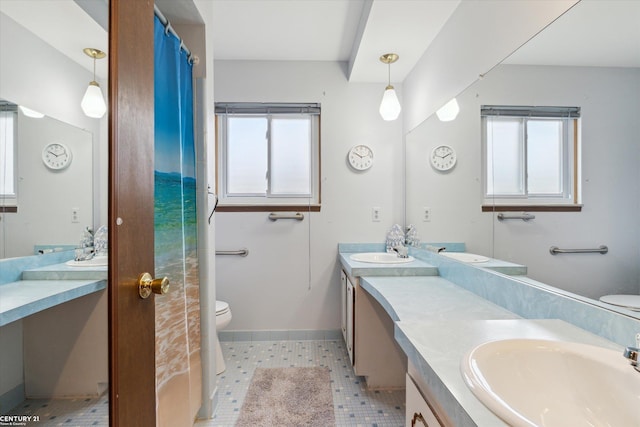 full bathroom with toilet, baseboards, a wealth of natural light, and vanity