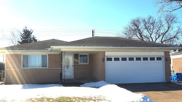 view of front facade featuring driveway, brick siding, and an attached garage