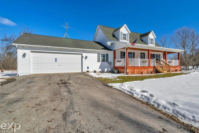 view of front of home featuring driveway, covered porch, and an attached garage