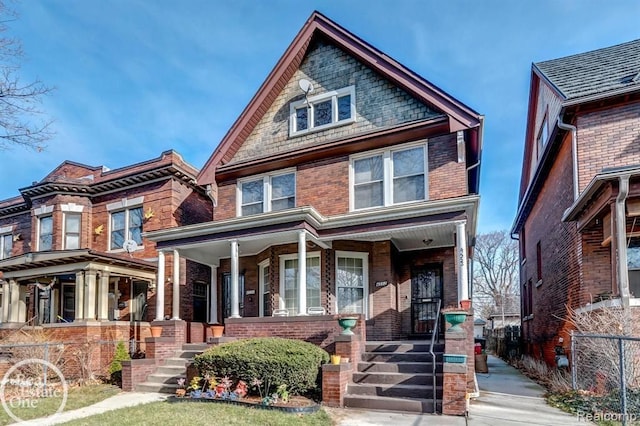 view of front of home featuring covered porch and brick siding