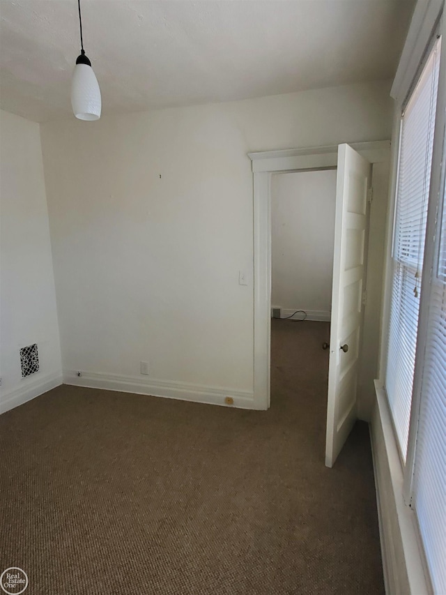 empty room featuring carpet flooring and baseboards