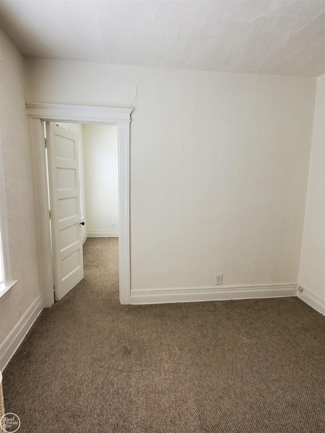 carpeted spare room with baseboards