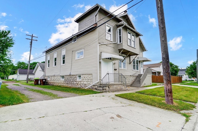 view of front facade with a front yard and fence