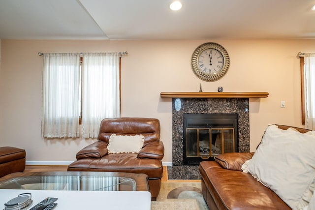 living room featuring a tile fireplace, recessed lighting, baseboards, and wood finished floors