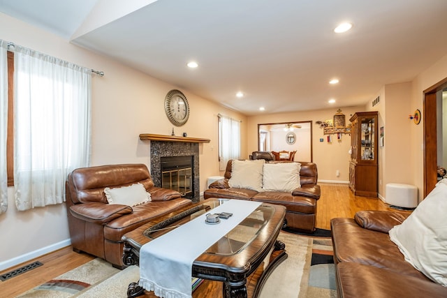 living area featuring a fireplace, wood finished floors, visible vents, and recessed lighting