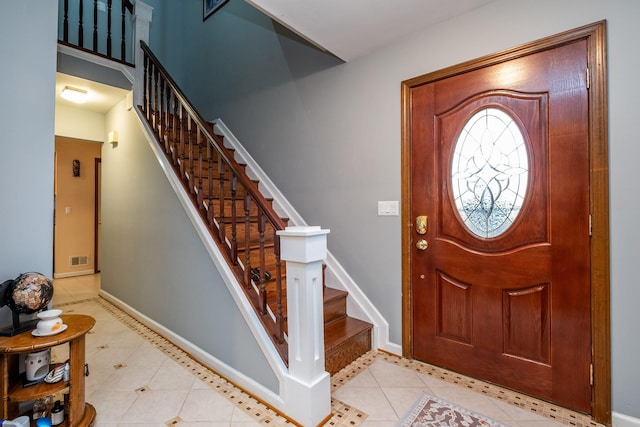 entrance foyer featuring light tile patterned floors, stairs, visible vents, and baseboards