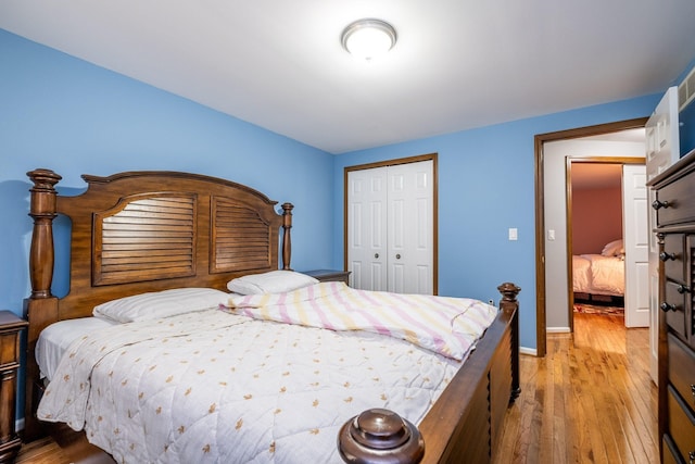 bedroom featuring a closet, light wood-style flooring, and baseboards