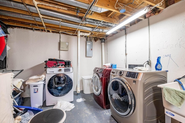 washroom featuring laundry area, washer and clothes dryer, a sink, and electric panel