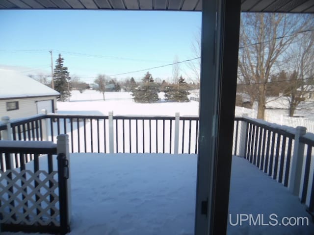 snow covered deck with fence and an outbuilding