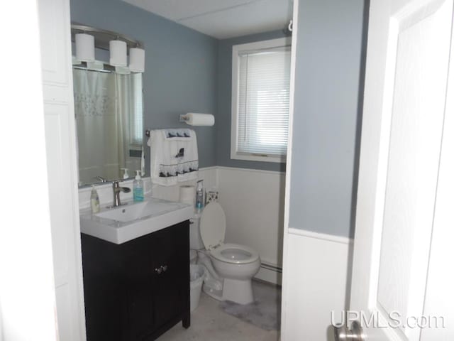 full bathroom with concrete flooring, a baseboard radiator, toilet, a shower with shower curtain, and vanity