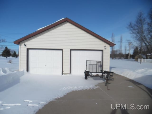 snow covered garage with a garage