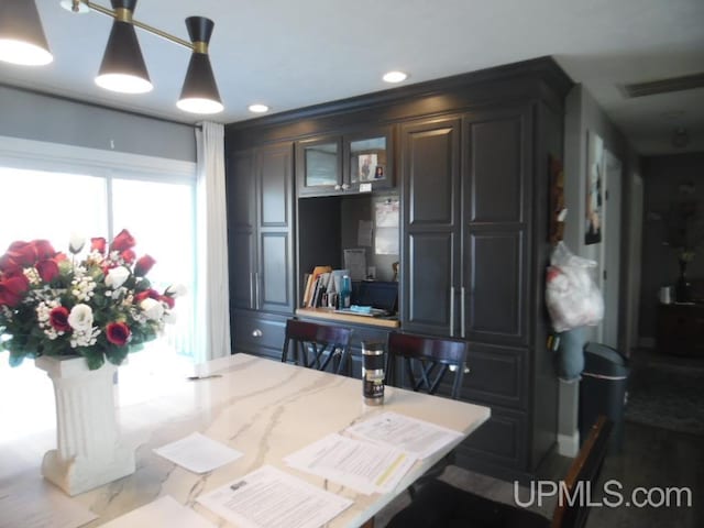 kitchen featuring visible vents, hanging light fixtures, glass insert cabinets, and recessed lighting