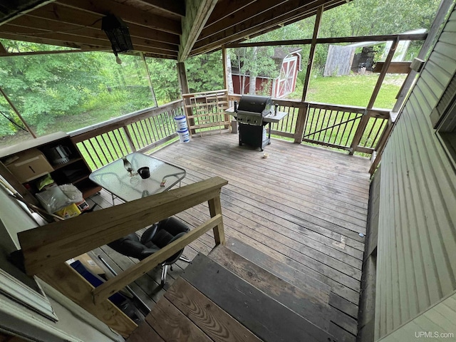 wooden terrace with a shed, an outbuilding, grilling area, and a yard