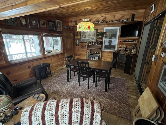 dining space with wood ceiling and wooden walls