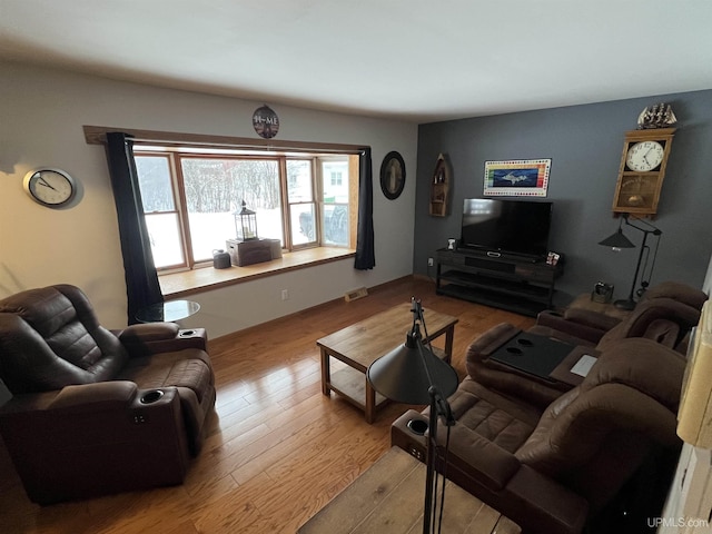 living area featuring visible vents and wood finished floors