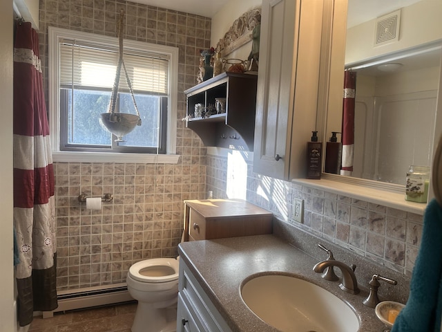 bathroom with a baseboard radiator, toilet, vanity, visible vents, and tile walls